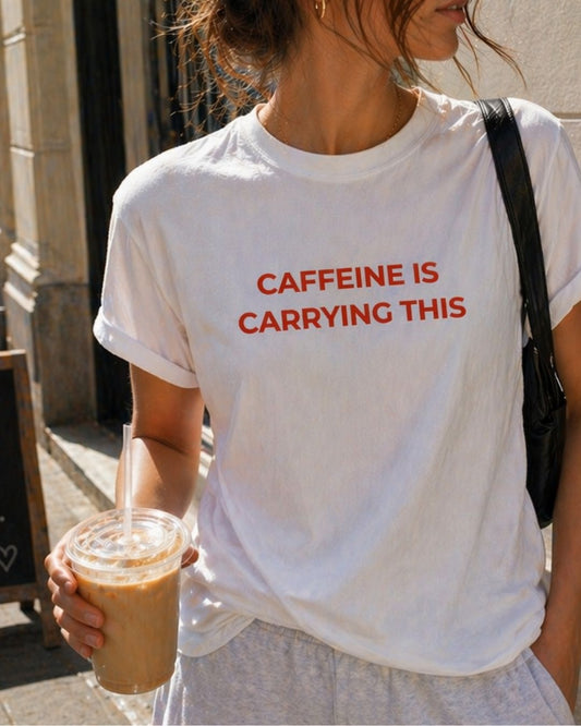 Caffeine Is Carrying This organic graphic T-shirt with funny coffee quote printed on front in minimalist design